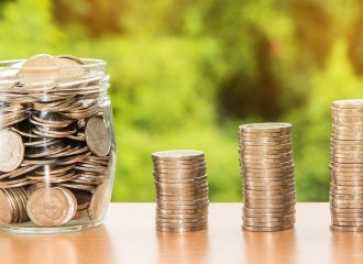 Piles of coins and glass jar full of coins to represent Drawdown