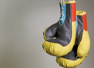 Pair of boxing gloves to illustrate Pensions vs ISAs
