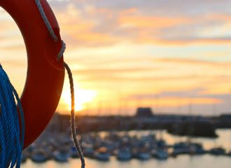 Ring and rope on boat by harbour to illustrate life cover