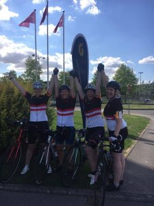 Cycling team posing outside Commonwealth War Memorial Cemetery in Arras