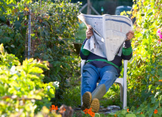 Man reading paper in garden