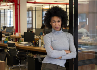 Successful woman entrepreneur with arms folded outside office
