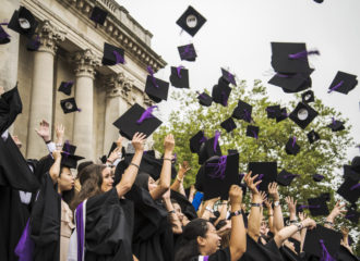 Students throwing their mortarboards in the air at graduation