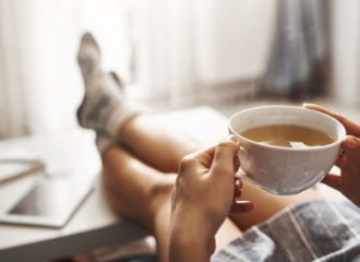 person relaxing with a cup of tea-feet on the coffee table