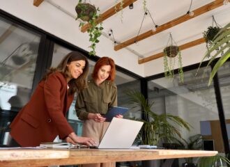 Two businesswomen talking over a laptop